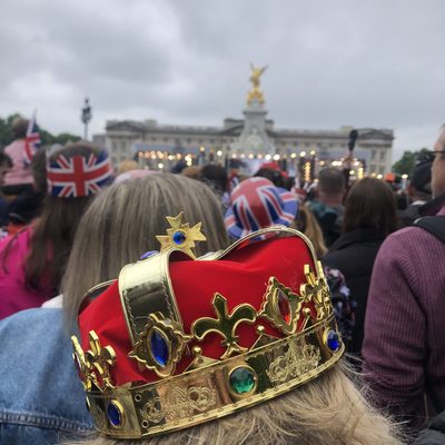 A woman wearing a crown in a crowd for Queen Elizabeth's Platinum Jubilee