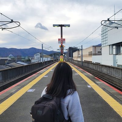 A woman staring down a set of railroad tracks in Kyoto