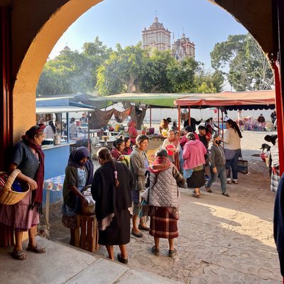 A group of people in the market, viewed through an archway