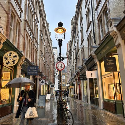A man with an umbrella walking down a London street