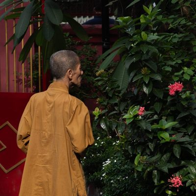 A monk smelling flowers