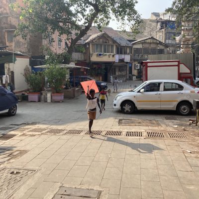 Kids running down a street with a kite