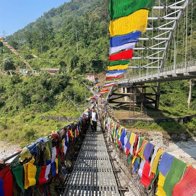 A man walking on a brightly-decorated bridge