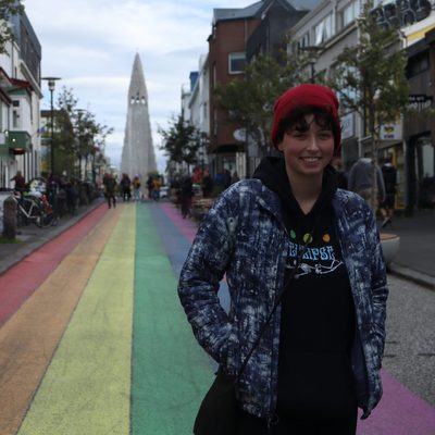 A student on a rainbow-painted street