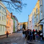 people wait in a line on a European street corner