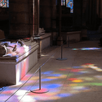 light pours in through stained glass windows in a French cathedral