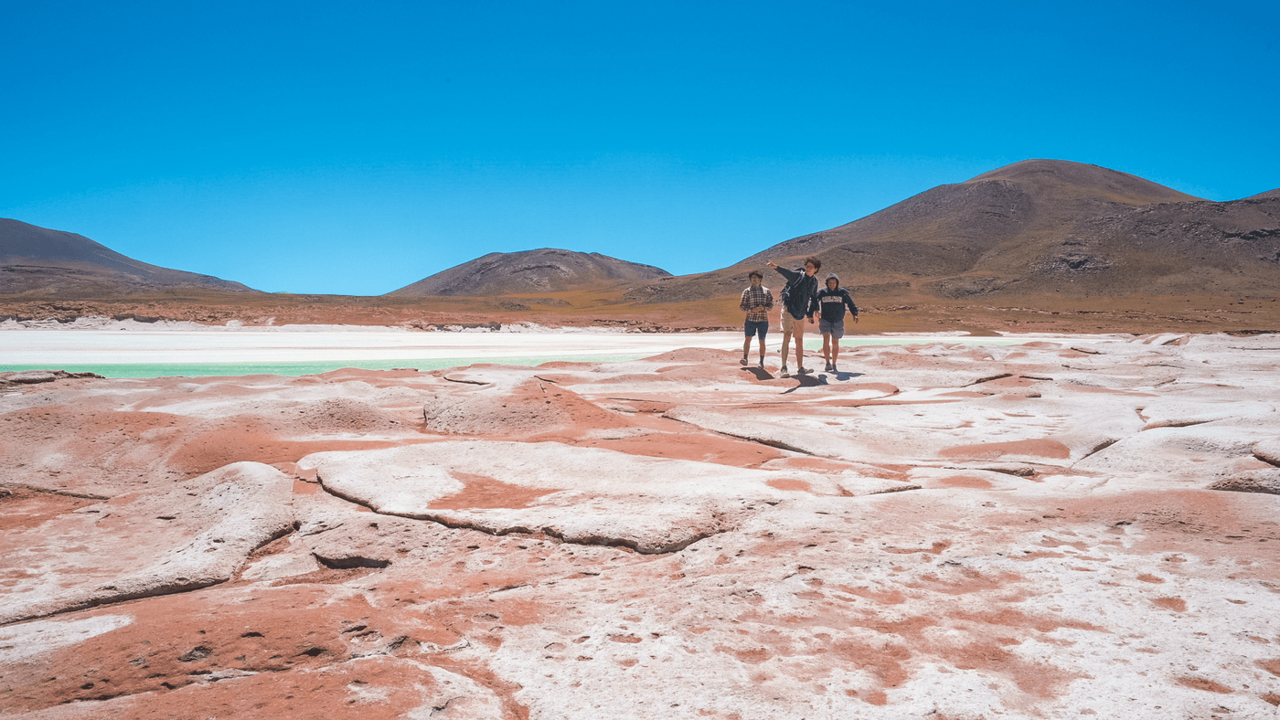three students standing in the desert