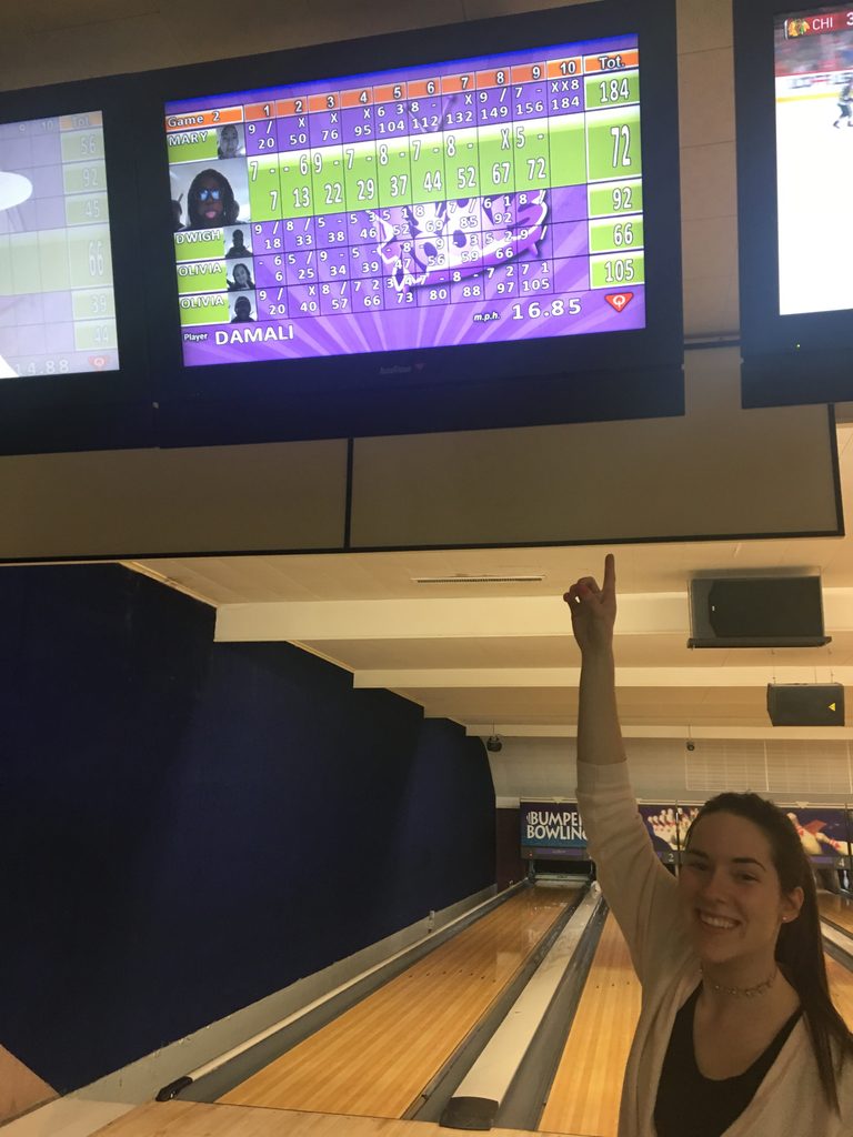 a student points to a bowling alley scoreboard