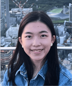 Young asian woman wearing a denim jacket with big city behind her