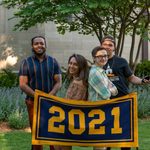 The senior banquet speakers and their introducers pose behind the maize and blue class banner, which reads 