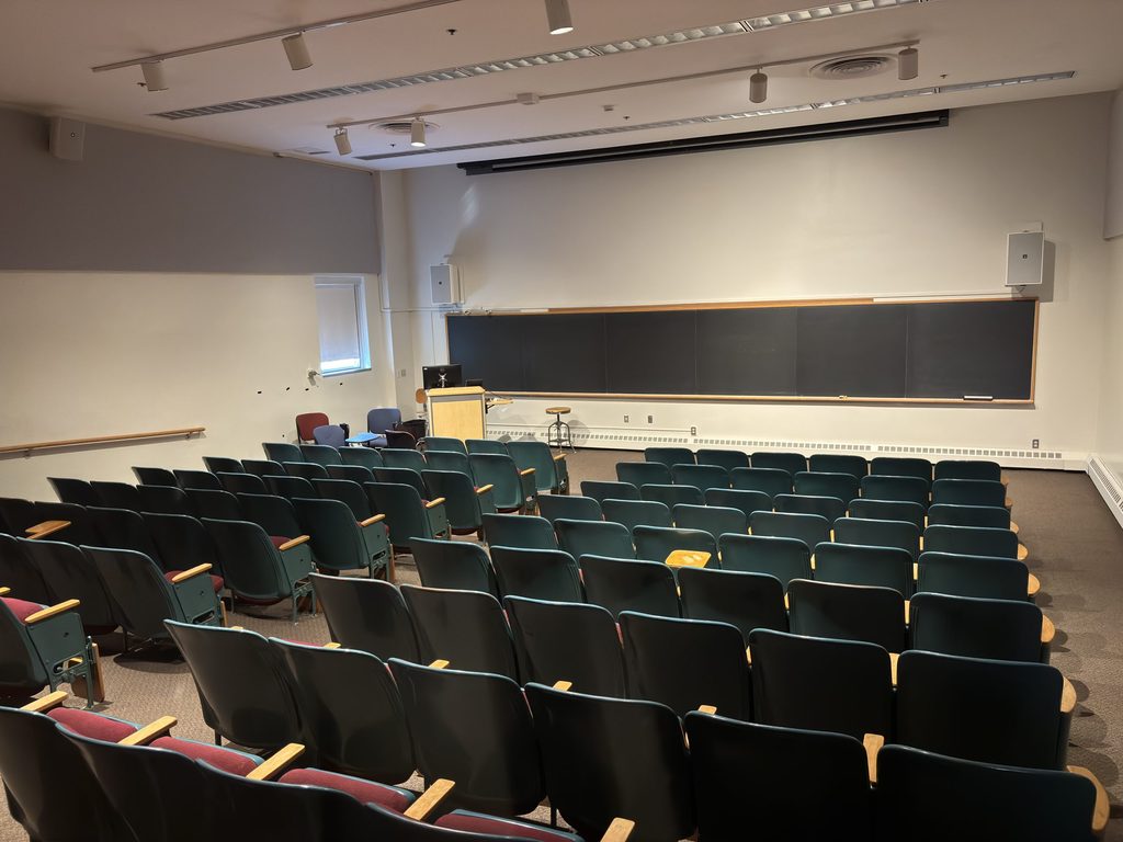 Boliou 104 auditorium, front view showing seating, instructor area, and chalkboard.