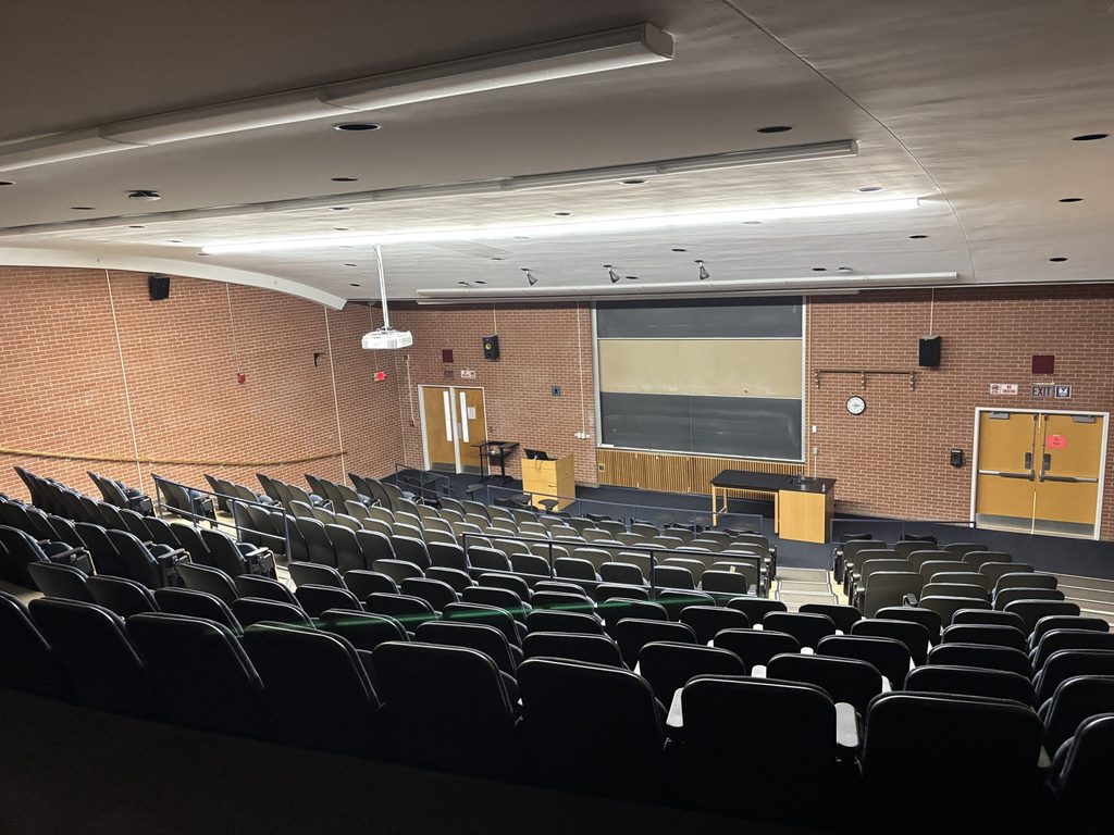 Olin 149 from the student seated at the corner station. Chairs arranged in tiered rows.