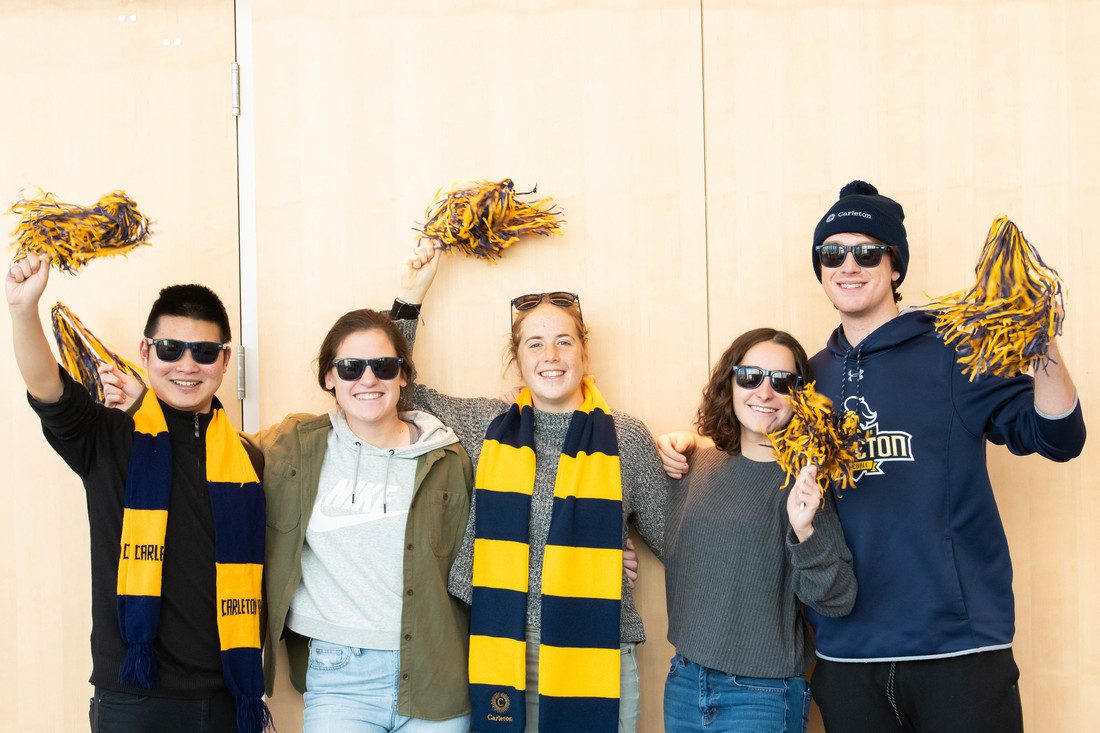 Students pose for a photo wearing Carleton gear