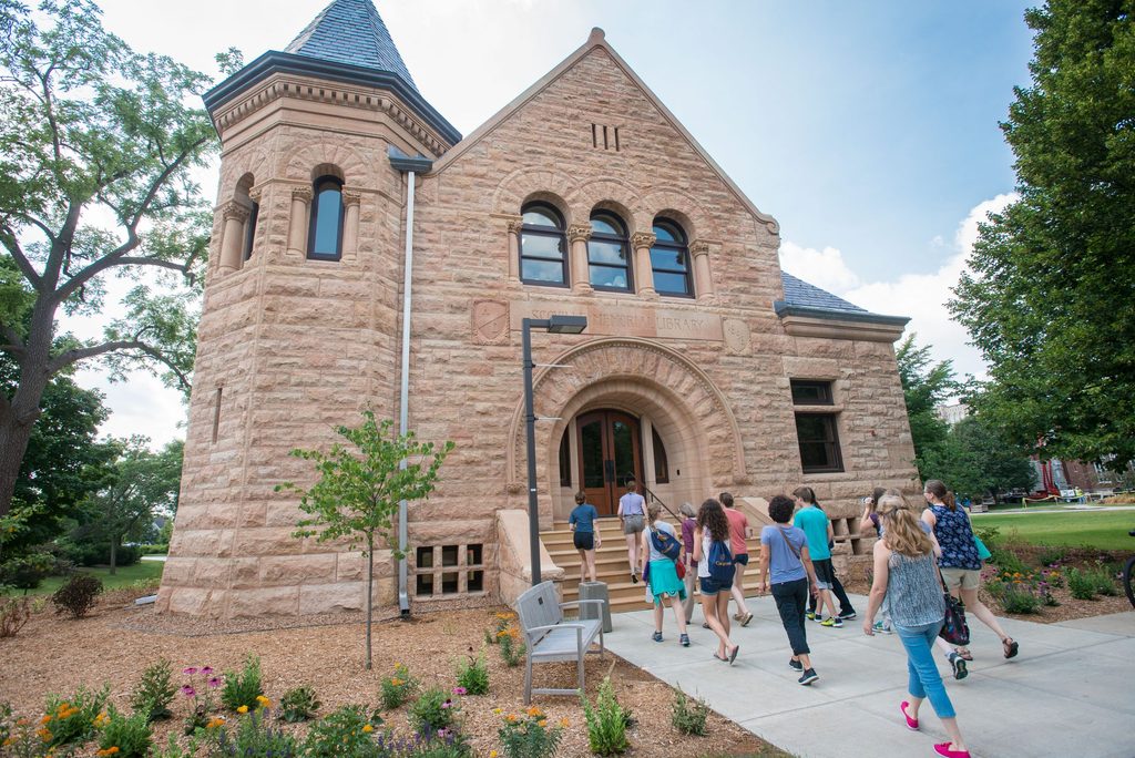 A group of prospective students walk past Scoville hall on a campus tour