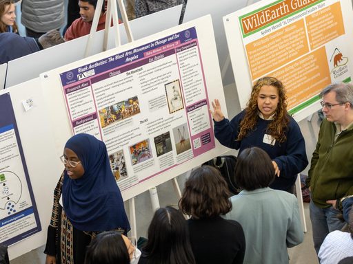 student pointing to a research poster