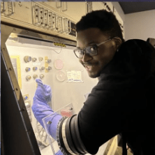 Student touching space rocks through controlled chamber