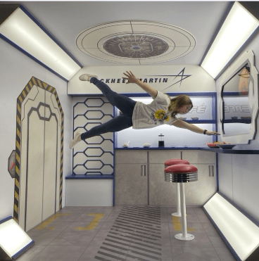 Student pretending to float in an anti-gravity chamber