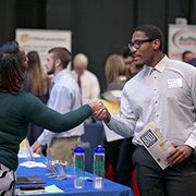 Student shaking hands with a recruiter at a job fair