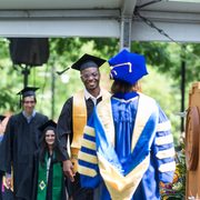 Class of 2023 student walking across graduation stage