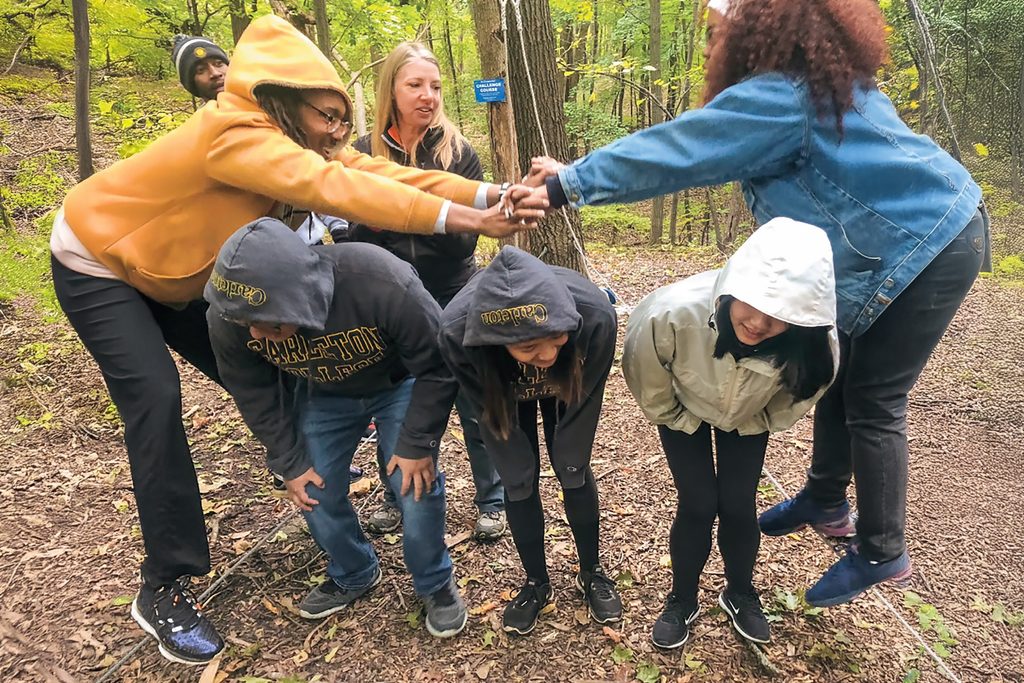 Students working together outdoors on a ropes course
