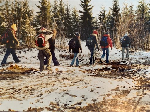 a group of students hiking in a pine forest in winter