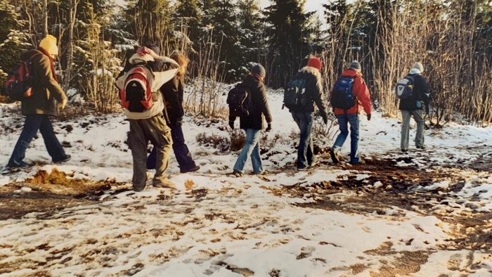 a group of students hiking in a pine forest in winter
