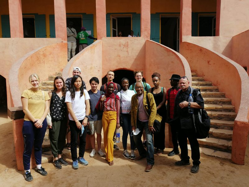 group picture of students in front of pink building in senegal