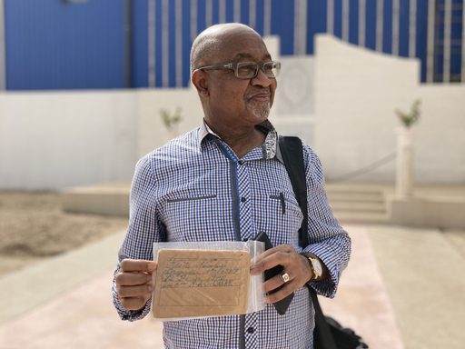 Cherif holding his father's military papers in Senegal