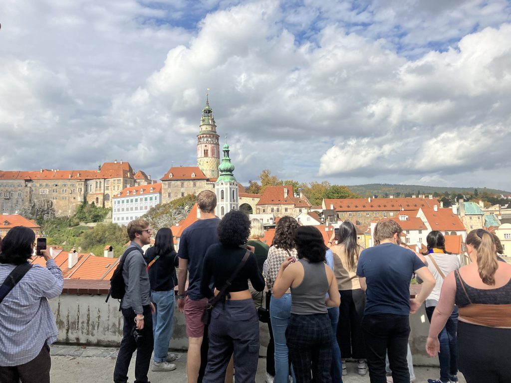 group of students looking at tower of Statni Hrad in the background
