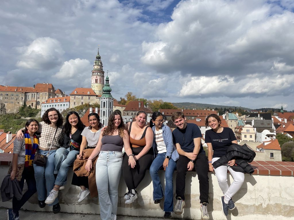 Group of students posing in front of city