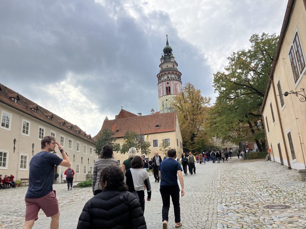 group of students walking up a hill to the castle tower