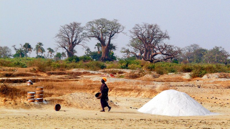 pile of salt desert with woman walking past in Senegal