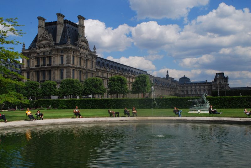 a large building with a pond in the foreground