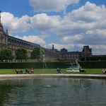 a large building with a pond in the foreground