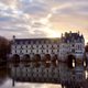 a castle built on a body of water in the sunset