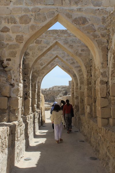 studnts walking through stone archways