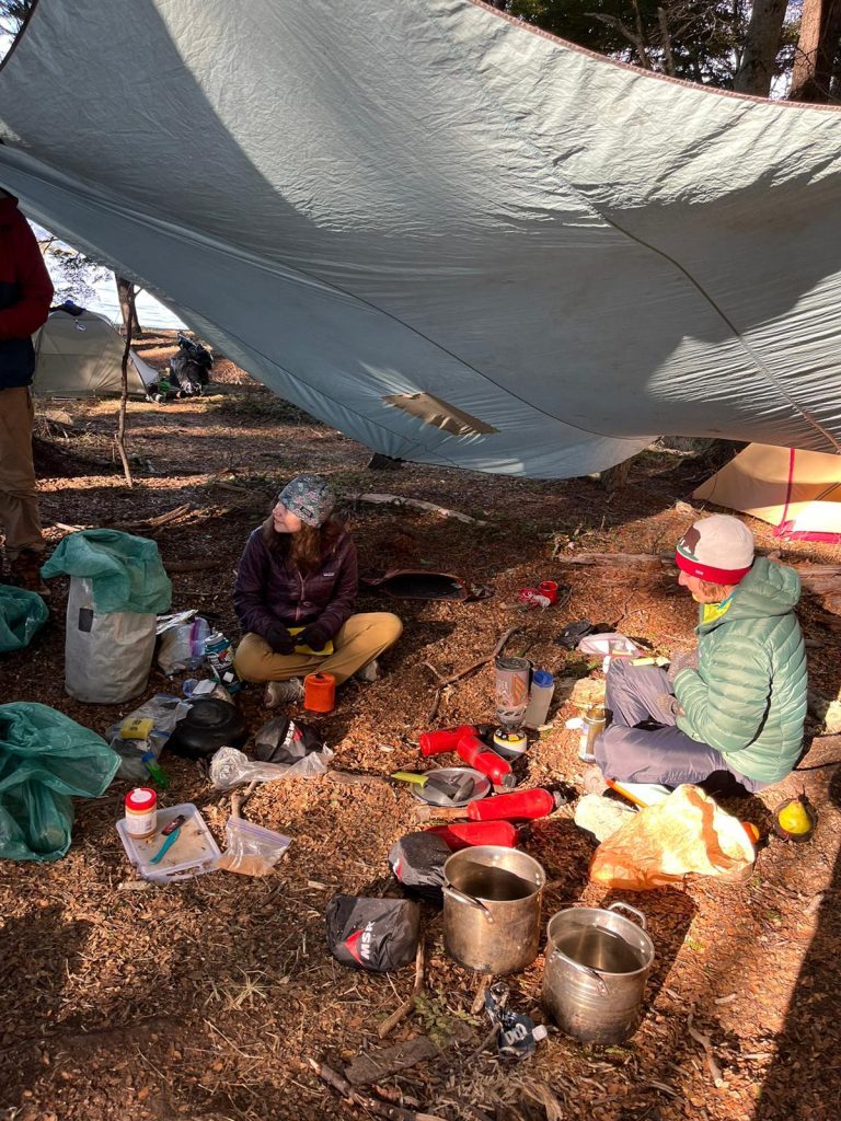 students eat meal at campsite