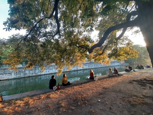 students sit on the edge of a canal