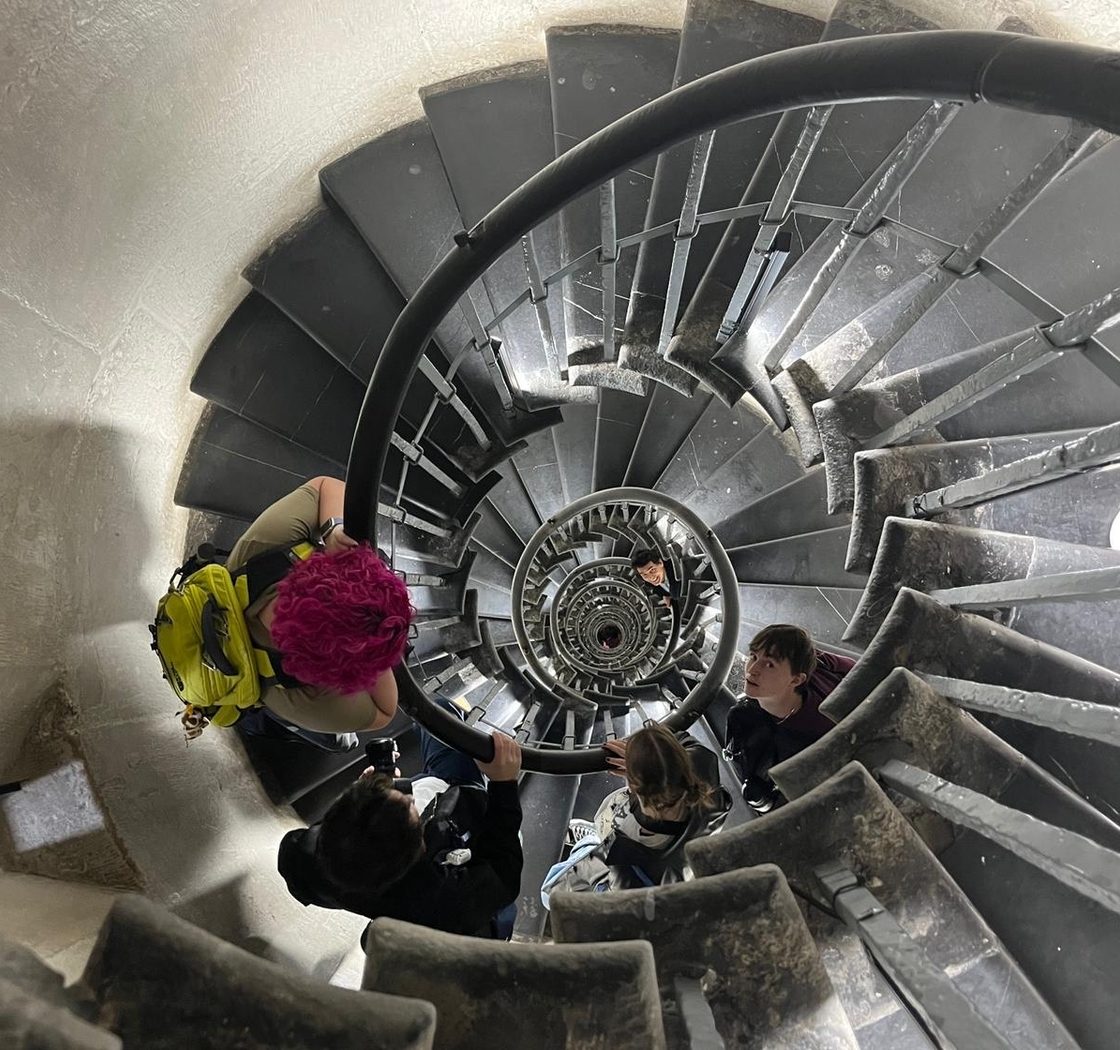 students stand on spiral staircase
