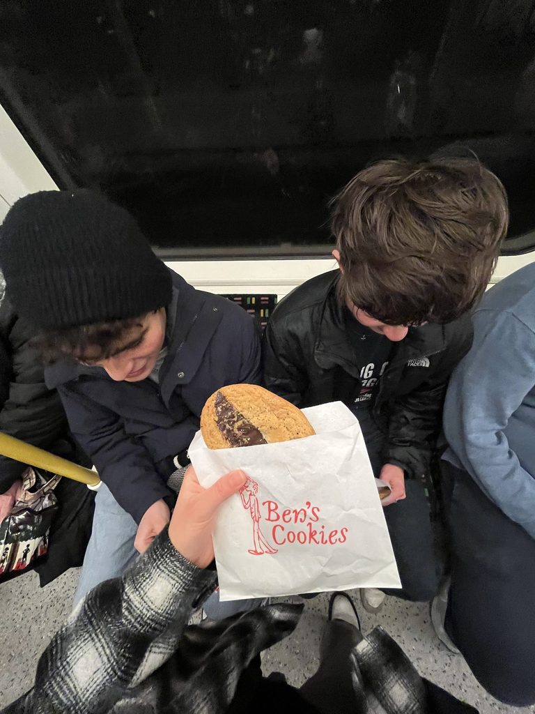 Three students ride the Tube and enjoy cookies