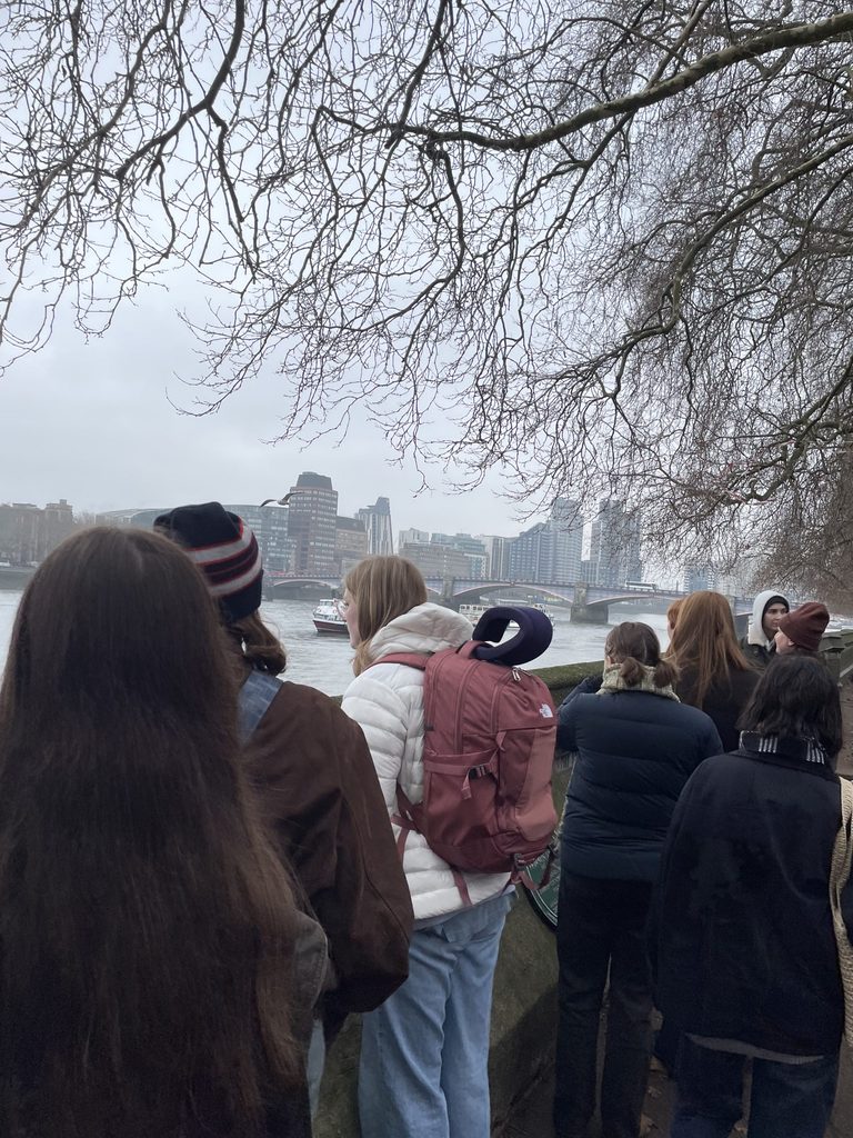 A group of students overlooks the Thames River