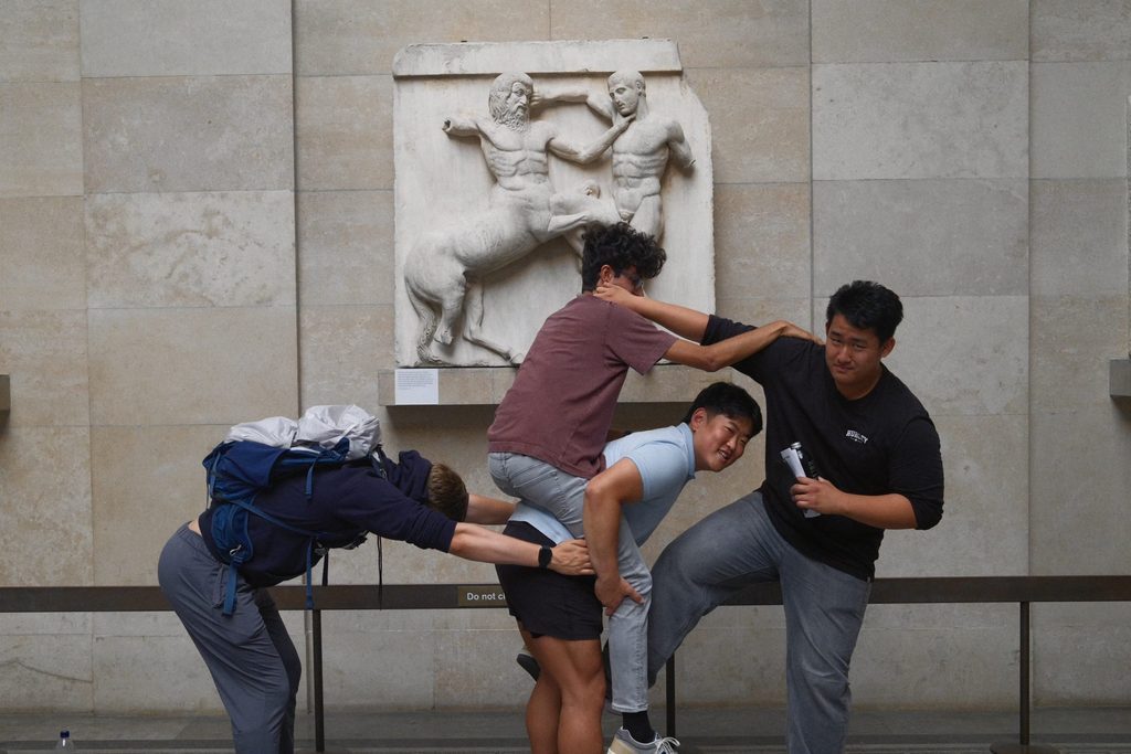 Students pose in front of art at the British Museum