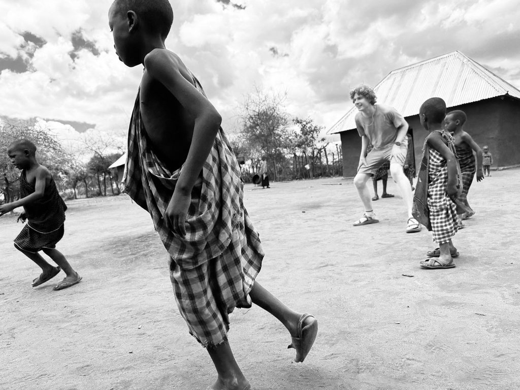 Students play soccer with kids