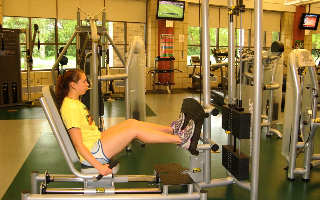 A student uses the seated leg press in the Fitness Center