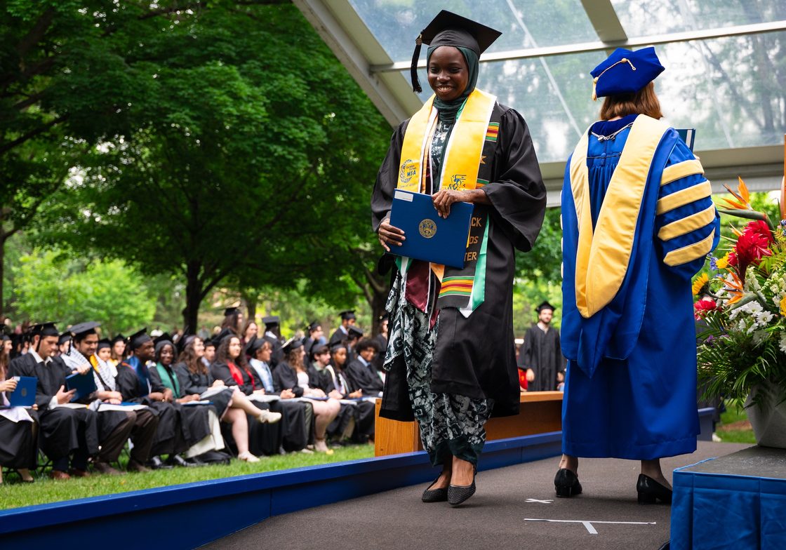 graduate accepting diploma onstage at commencement 2025