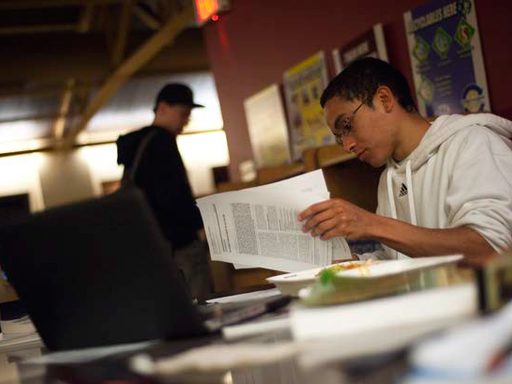 A student at a desk with papers spread all around him