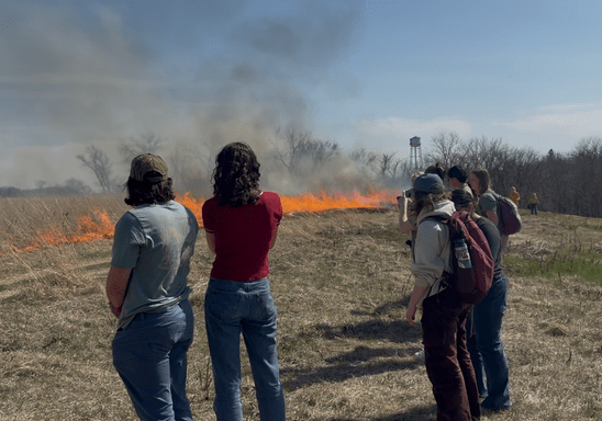 Students observe a prescribed prairie burn at the Cowling Arboretum
