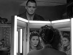 woman looking in mirror, man looking at woman