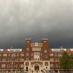 Stormy sky over a red brick dorm building