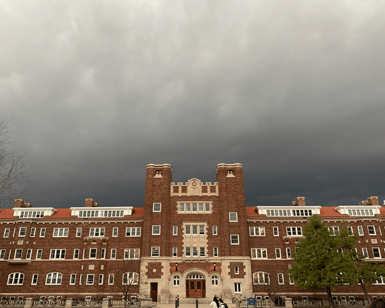 Stormy sky over a red brick dorm building